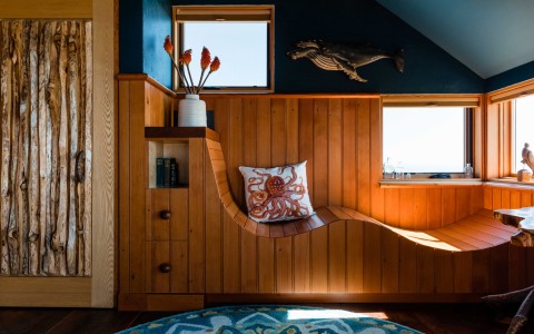 a wooden bench with a pillow and a vase on top of it