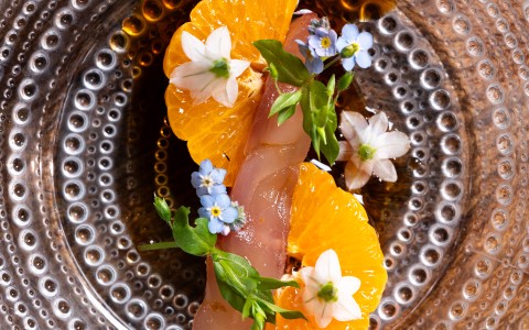a plate of food with flowers and meat