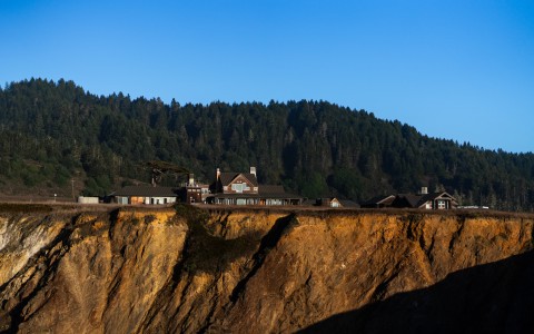 houses on a cliff with trees in the background