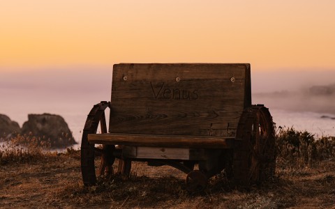 a wooden bench with wheels on it