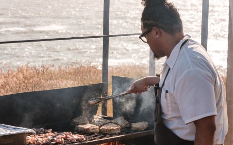 a man grilling meat on a grill
