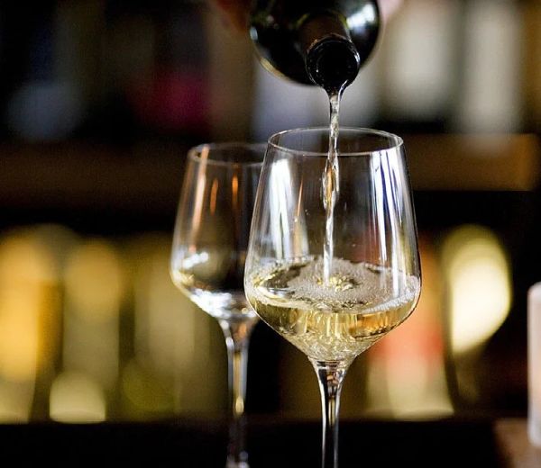 a person pouring wine into a glass