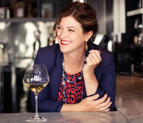 a woman sitting at a table with a glass of wine