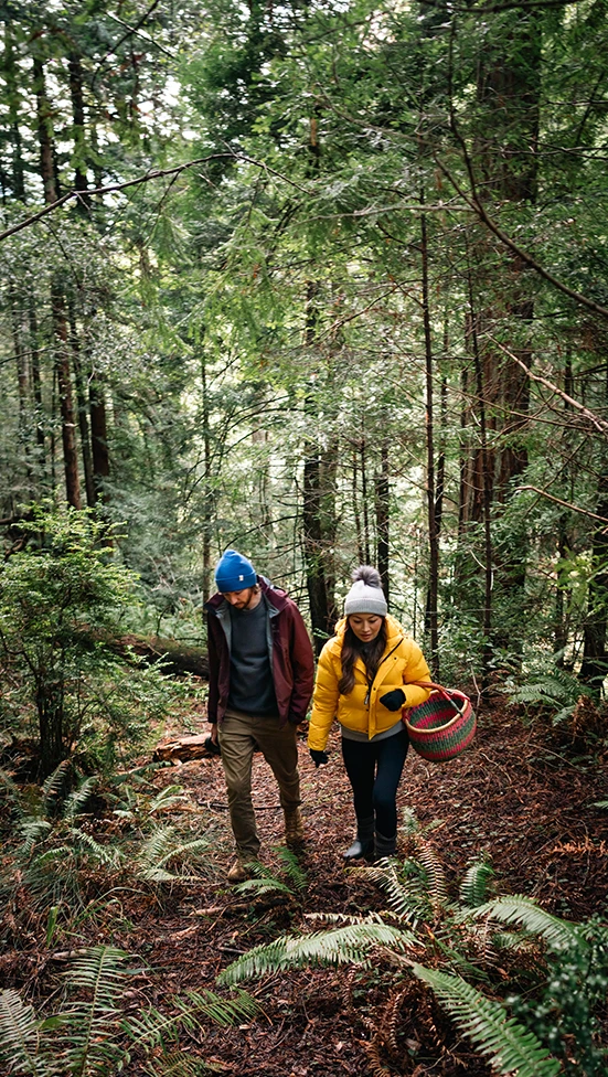 a man and woman walking in the woods