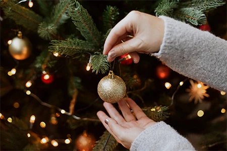a person holding a gold ornament