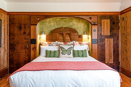 a bed with a pink blanket and pillows