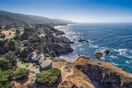 a rocky coastline with trees and a body of water