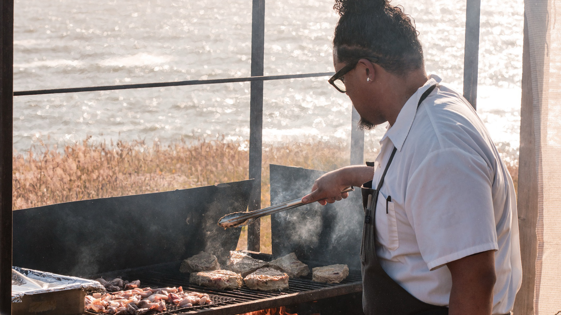 a man grilling meat on a grill