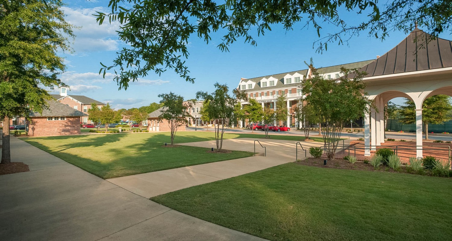 a sidewalk and trees in front of a building