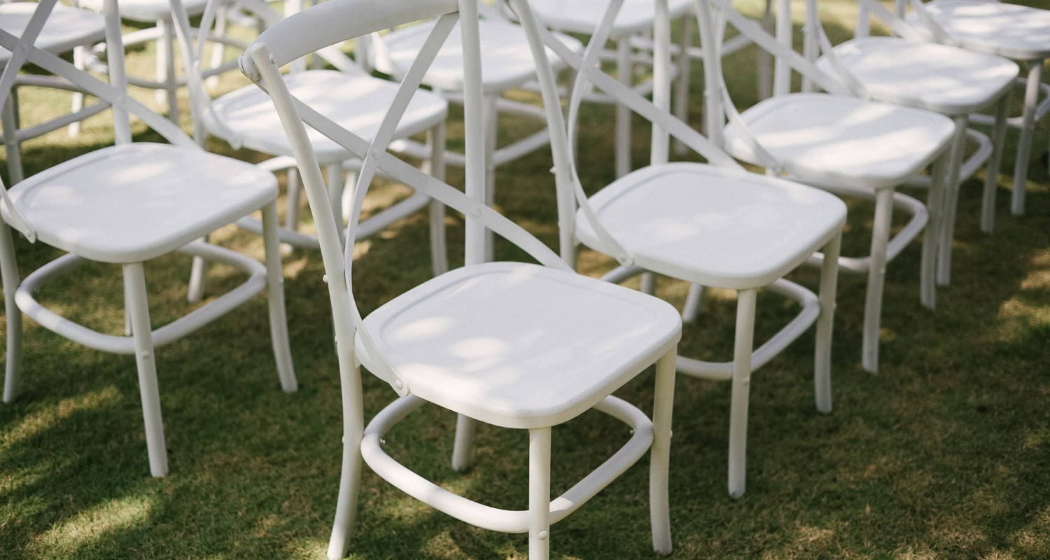 a group of white chairs on grass