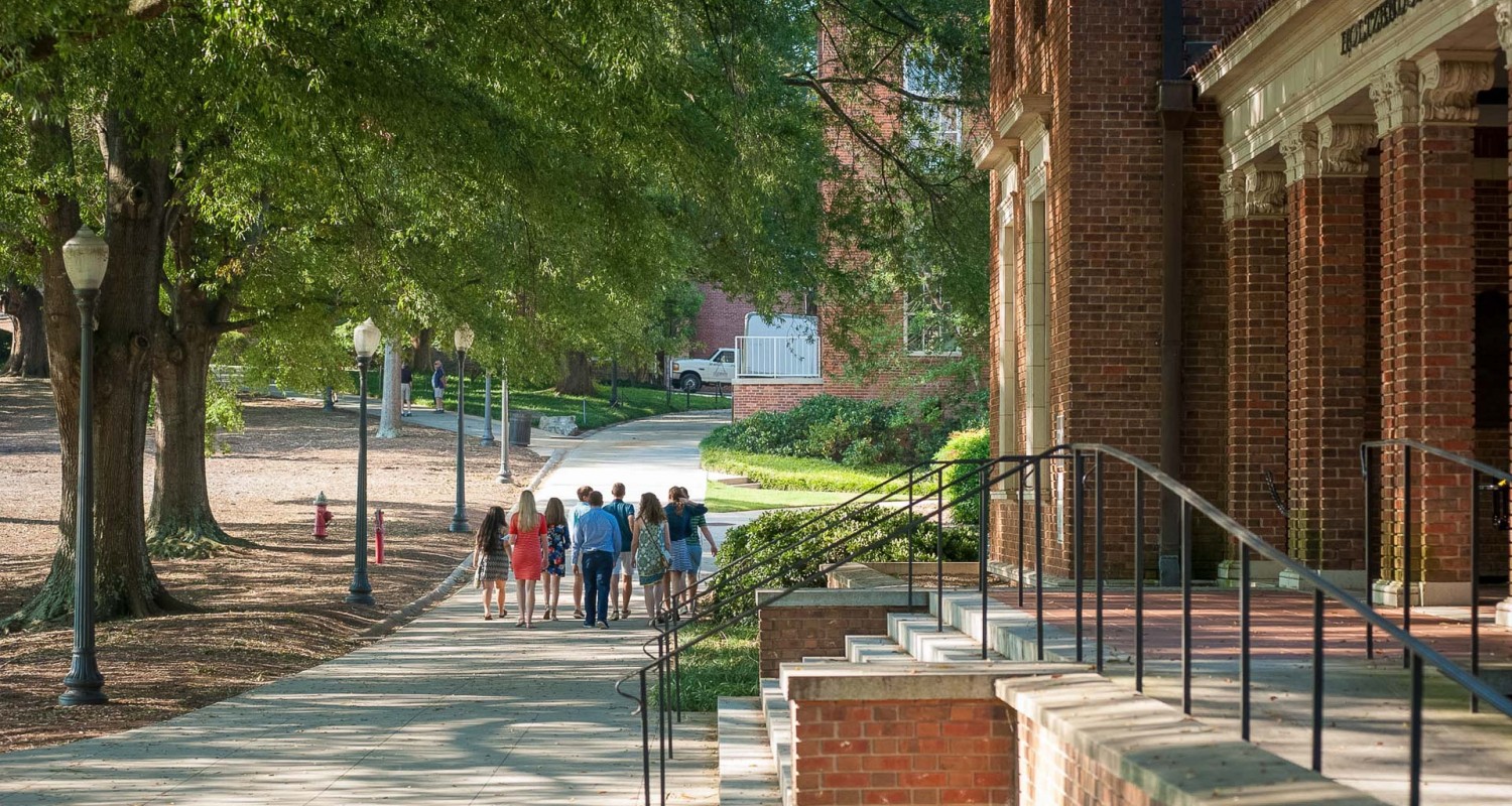 a group of people walking down a sidewalk