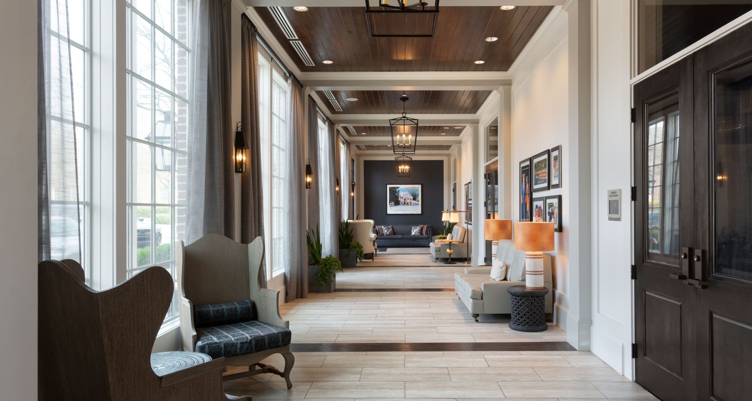 a hallway with chairs and a chandelier
