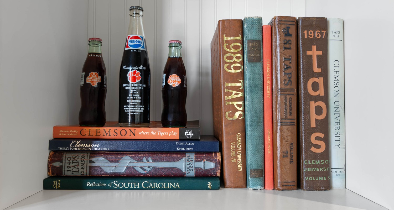a shelf with books and bottles of soda
