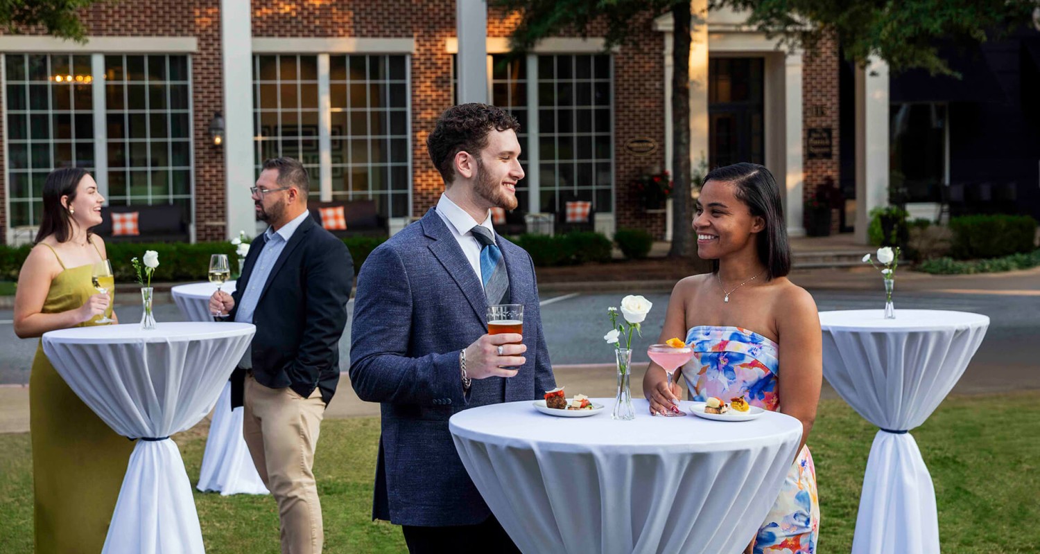 a man and woman standing at a table with drinks