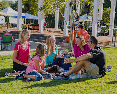 a group of people sitting on the grass