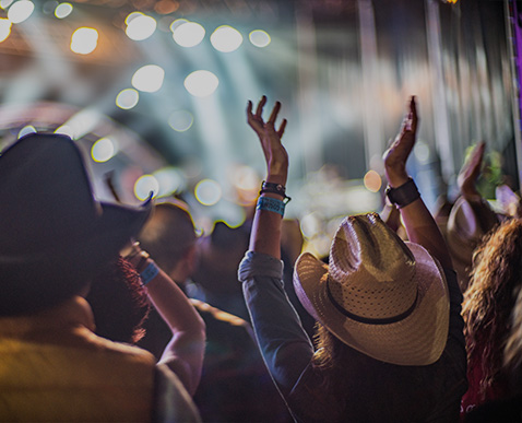 a crowd of people with their hands up in the air