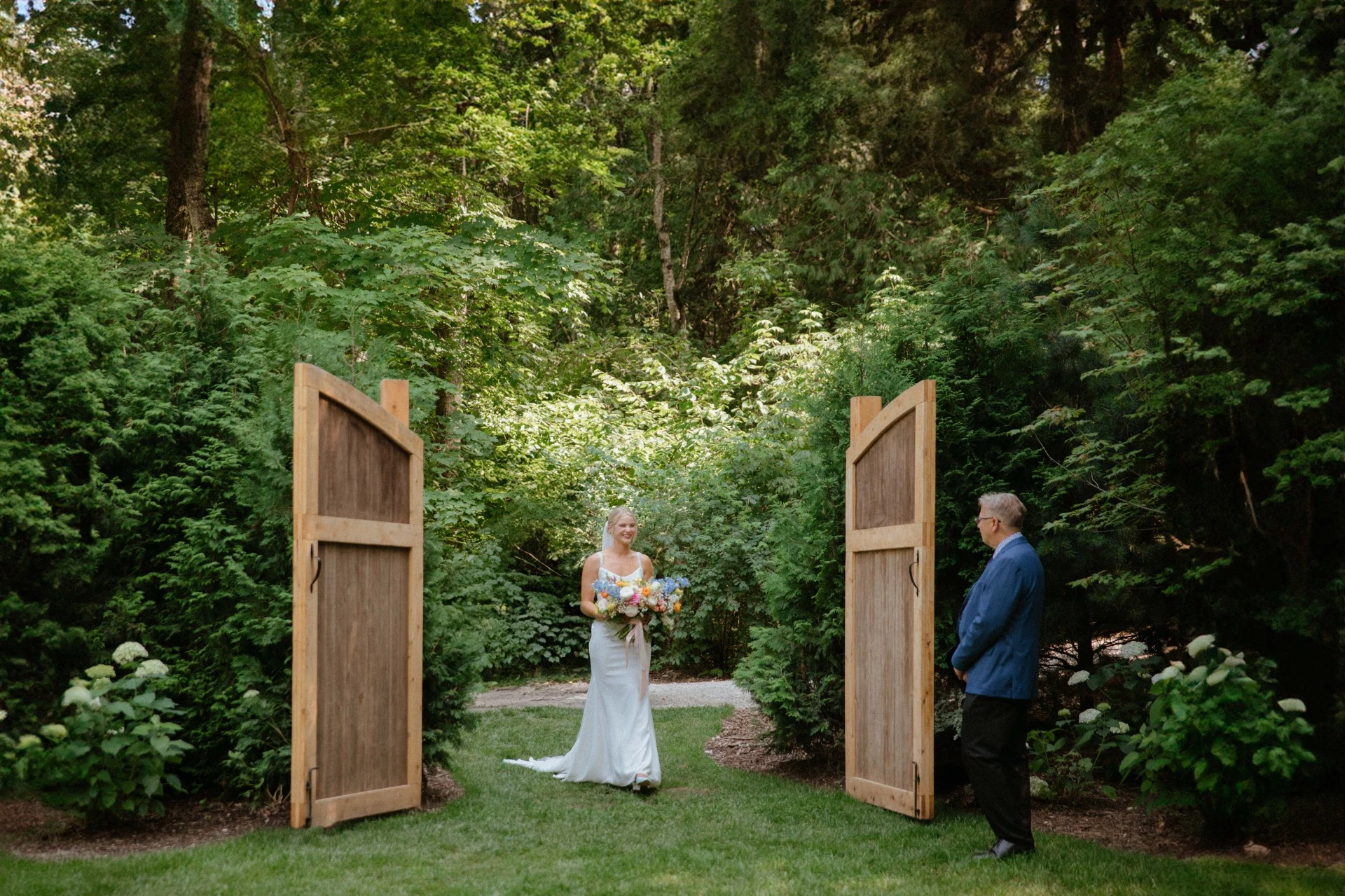 a man and woman walking through a garden
