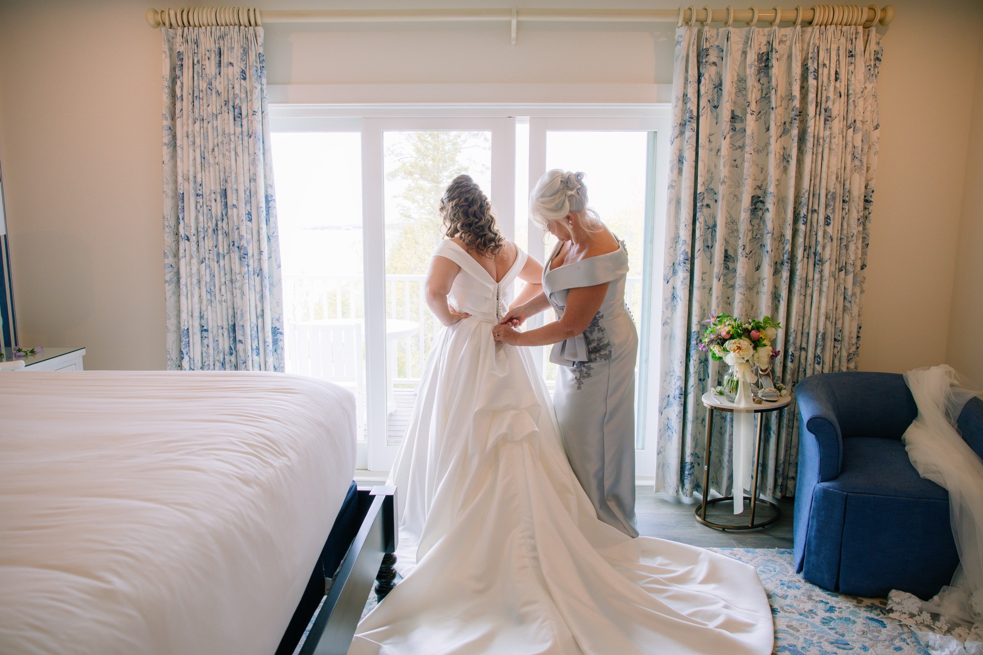 Mom helping Bride put wedding dress on 