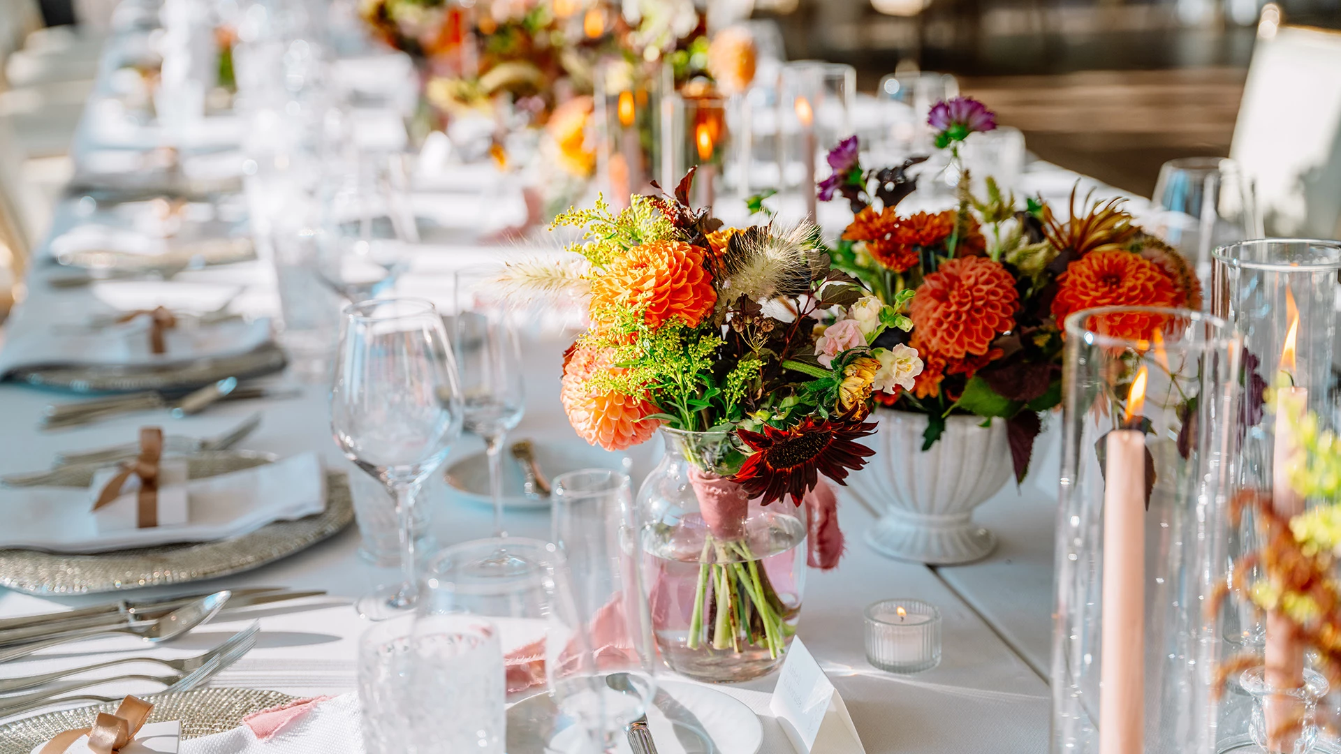 a table set with flowers and glasses