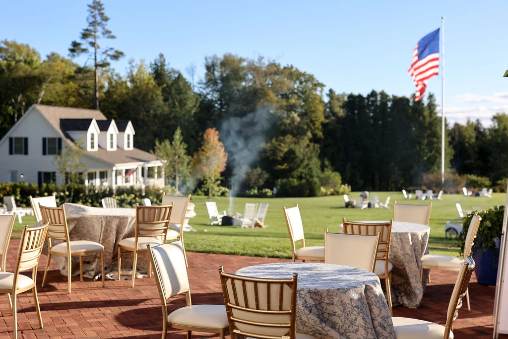 a patio with tables and chairs and a flag in the background