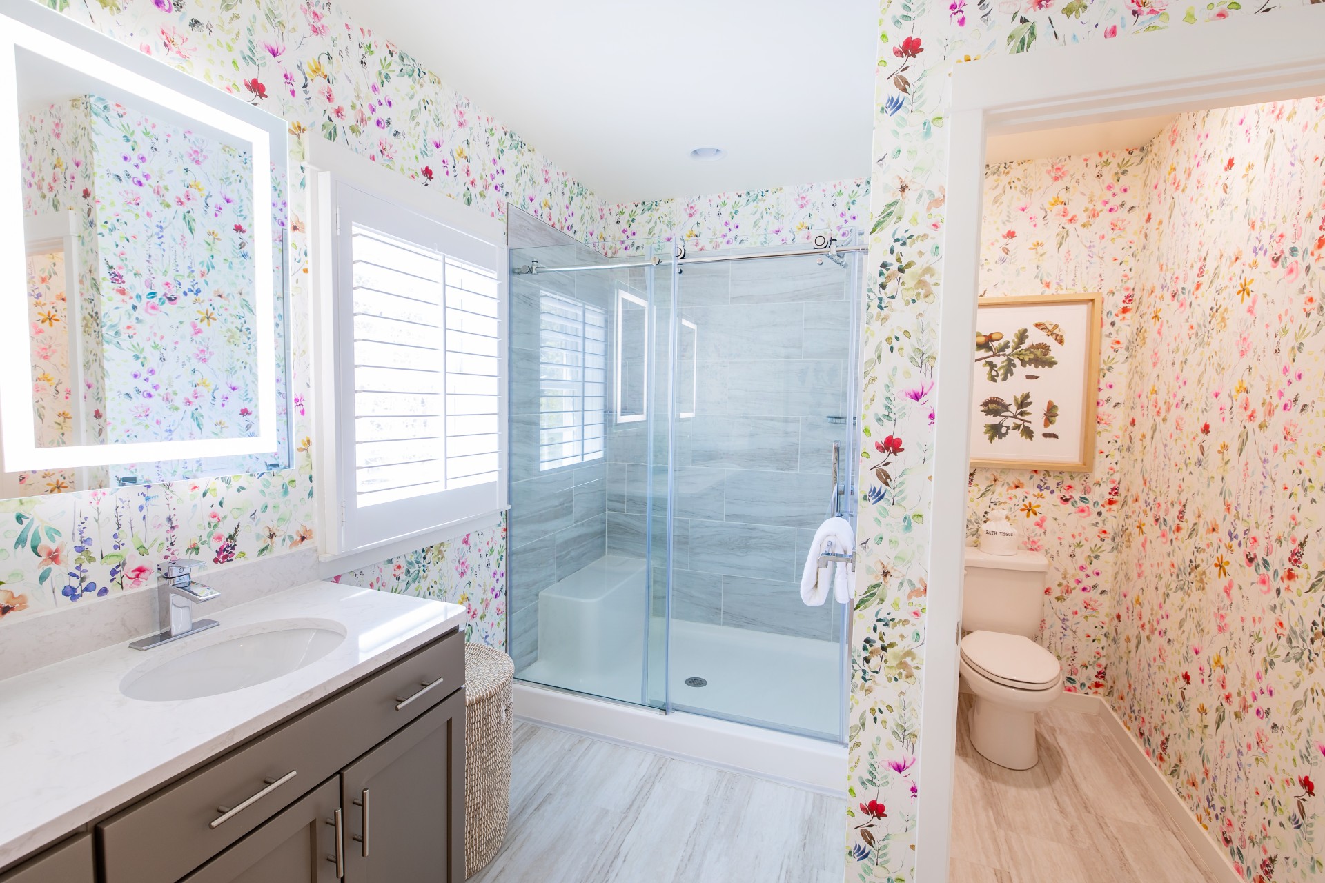 a bathroom with floral wallpaper and a shower