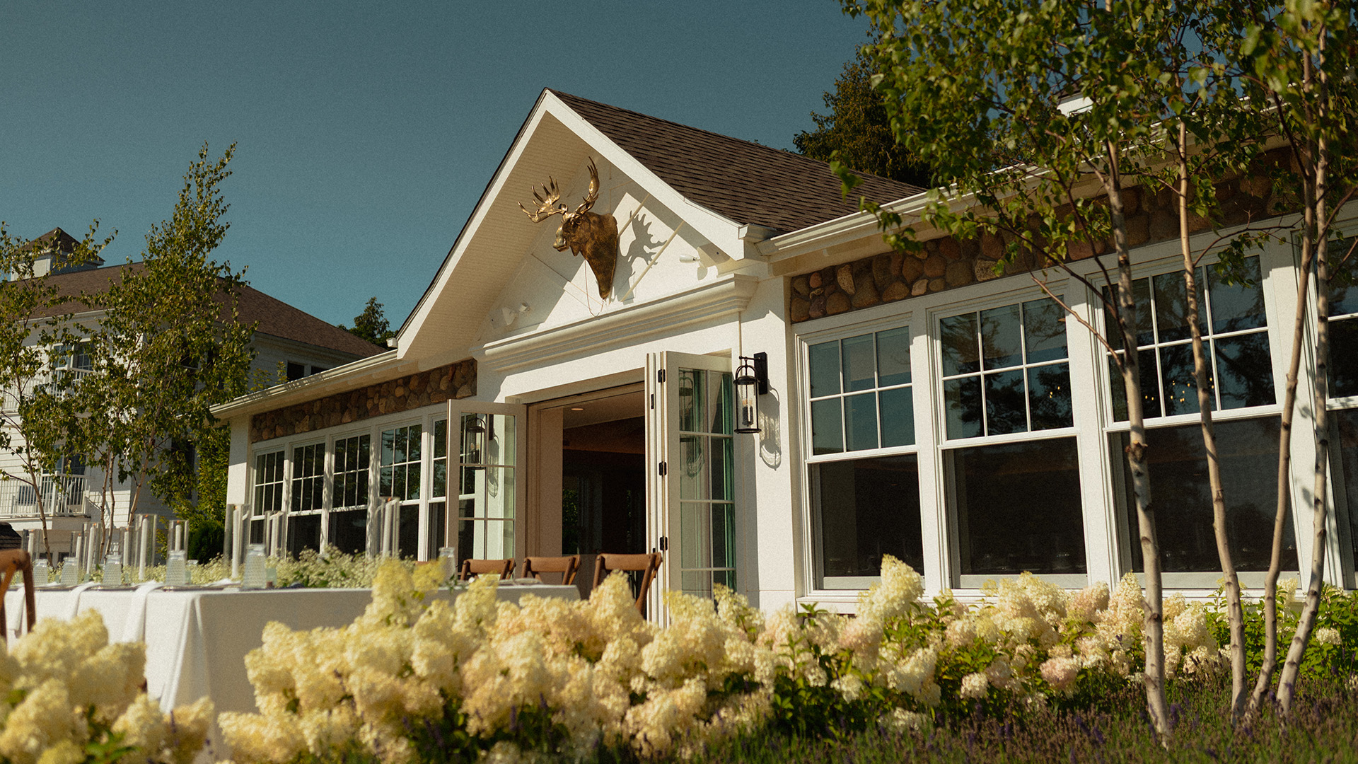 a house with a large white building with a large white flower garden