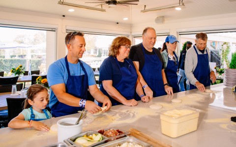 a group of people in aprons making food