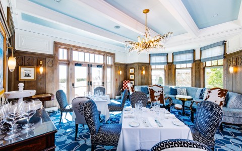a room with blue and white patterned chairs and tables