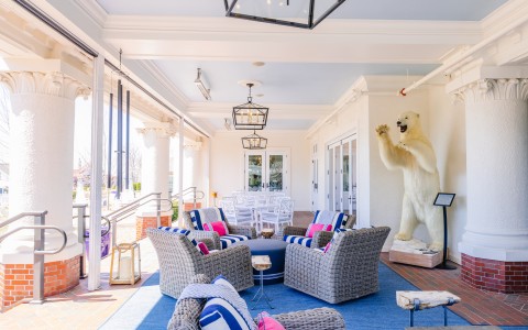 a large white bear statue on a blue rug outside a building