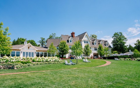 a large house with lawn and lawn chairs