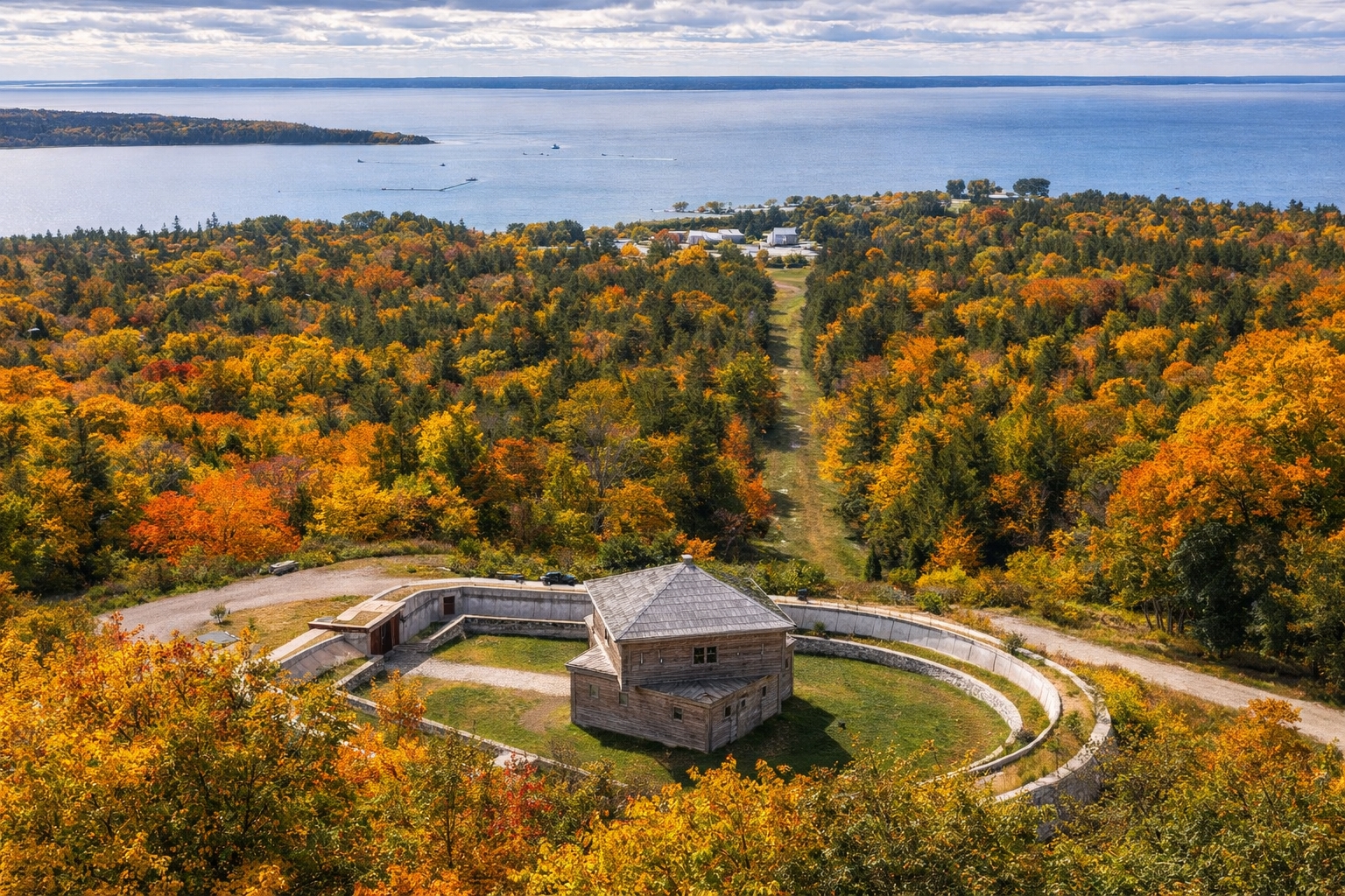Elevated view from Fort Holmes Overlook on Mackinac Island showing forested terrain and distant Lake Huron