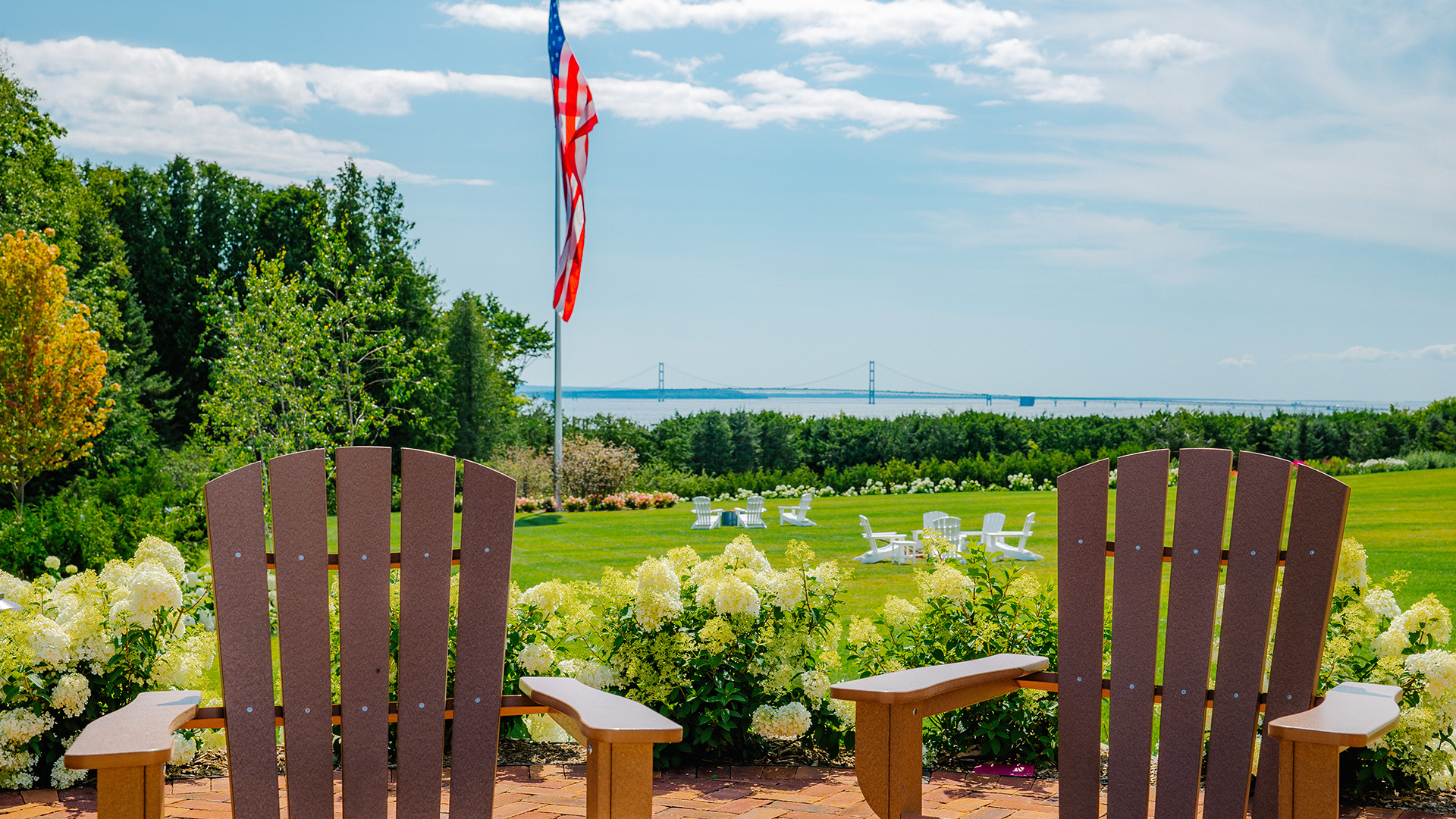 chairs in a park with a flag and a body of water