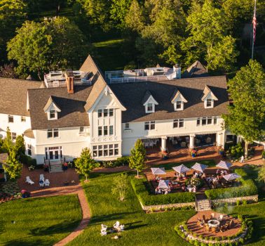 a large white house with a lawn and trees