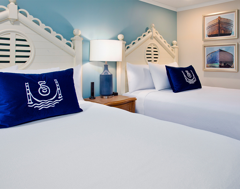 a two beds with pillows in a room