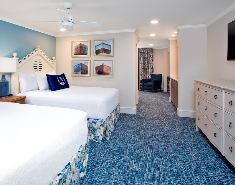 a room with two beds and a ceiling fan