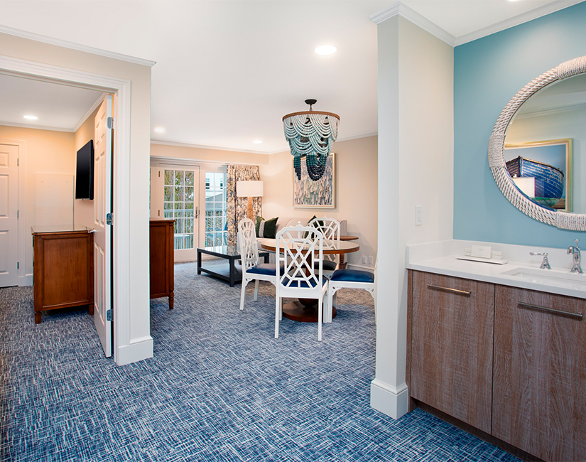 a room with blue carpet and white chairs