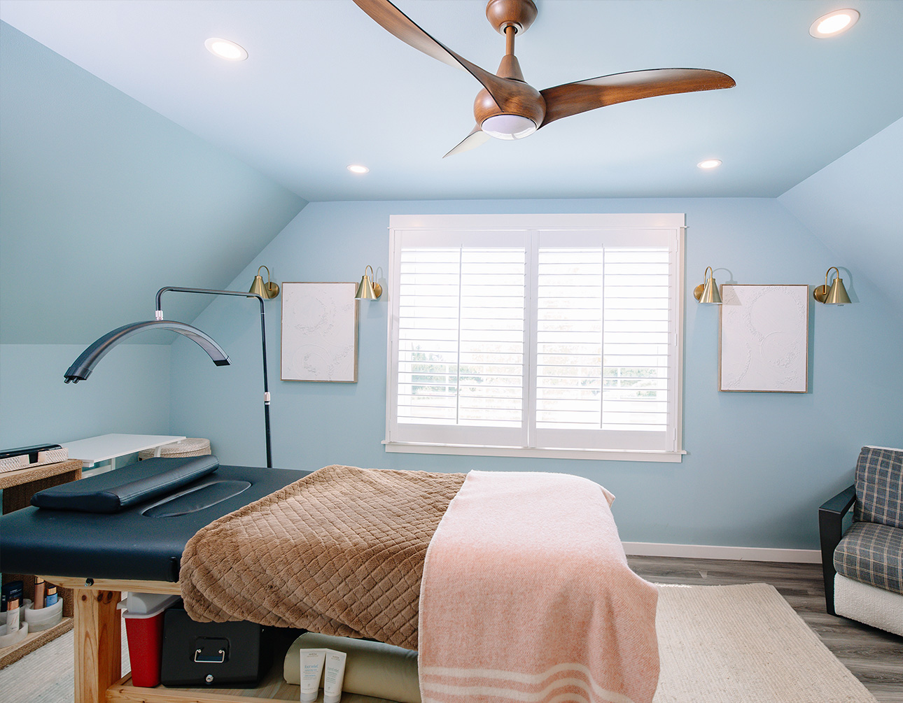 a room with a fan and a bed