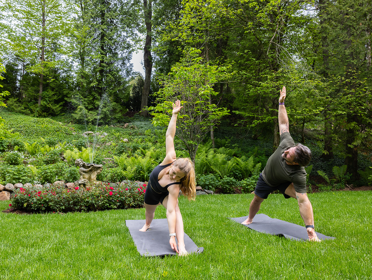 a man and woman doing yoga in a park