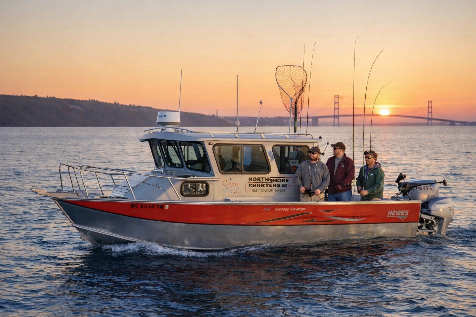 Sport fishing charter boat trolling for trout and salmon in the Straits of Mackinac near Mackinac Island with views toward the Mackinac Bridge, part of a Mackinac Island fishing charter experience near The Inn at Stonecliffe.