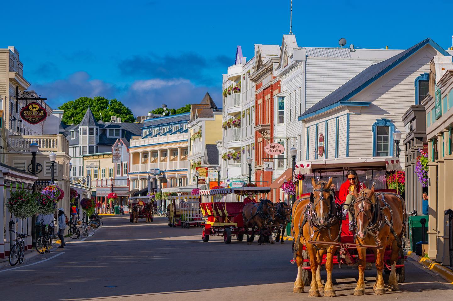 Mackinac Island fudge shops lining Main Street with historic storefronts and car-free pedestrian traffic