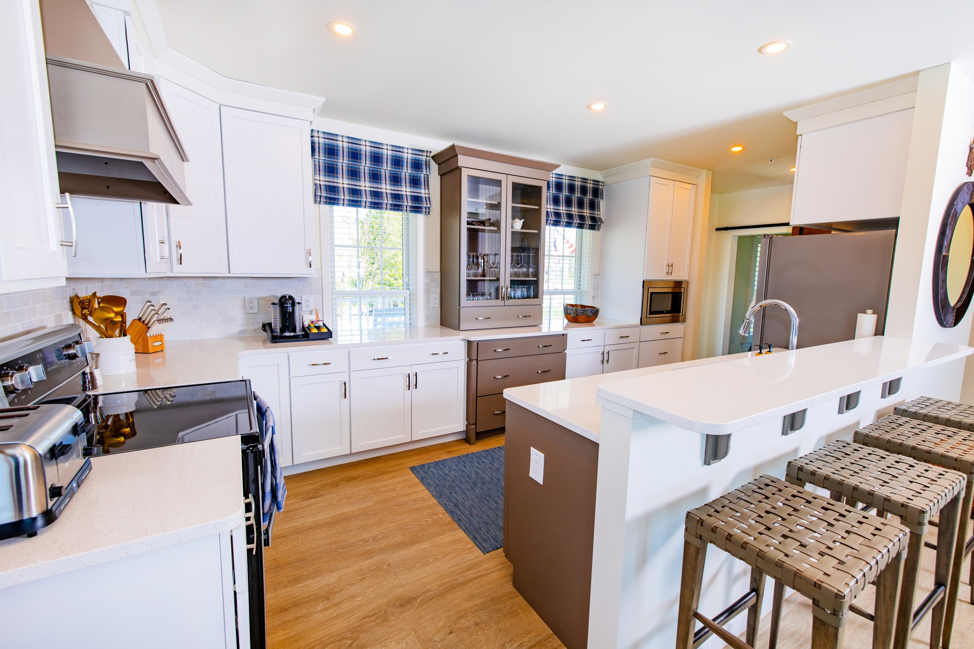 Full kitchen inside the Hilltop Cottage at The Inn at Stonecliffe featuring a large island, white cabinetry, and modern appliances on Mackinac Island