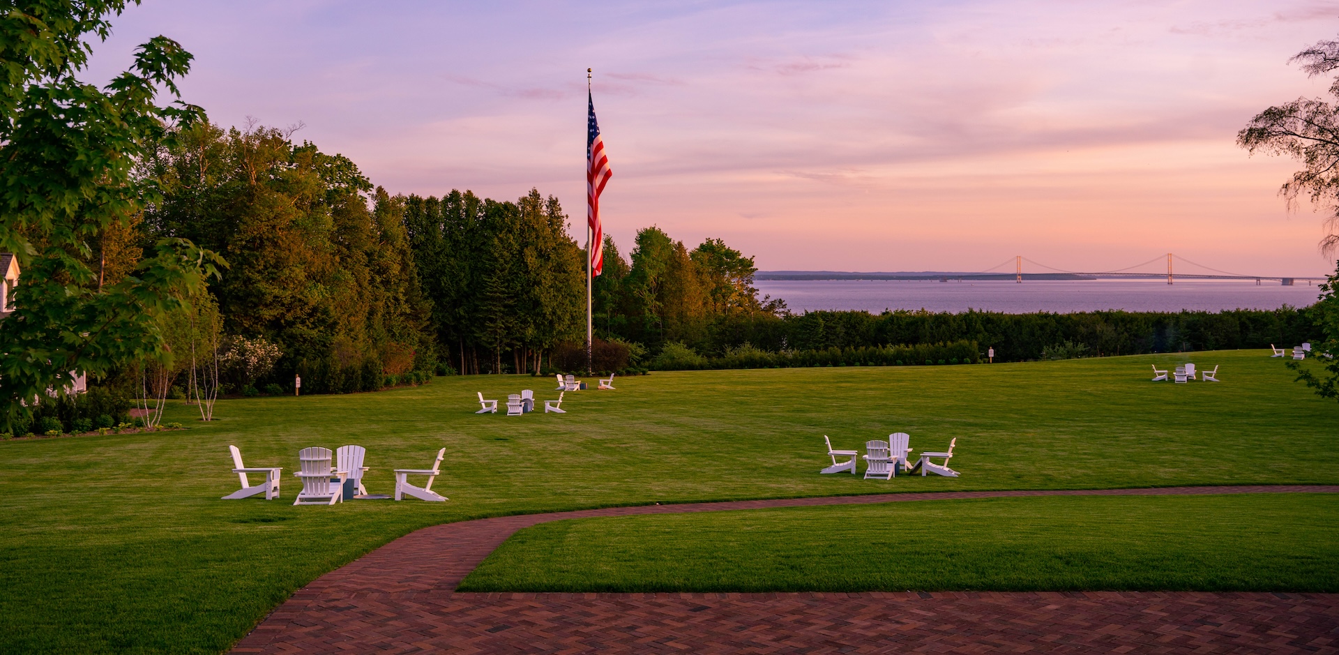 a lawn with chairs and a flag on the pole
