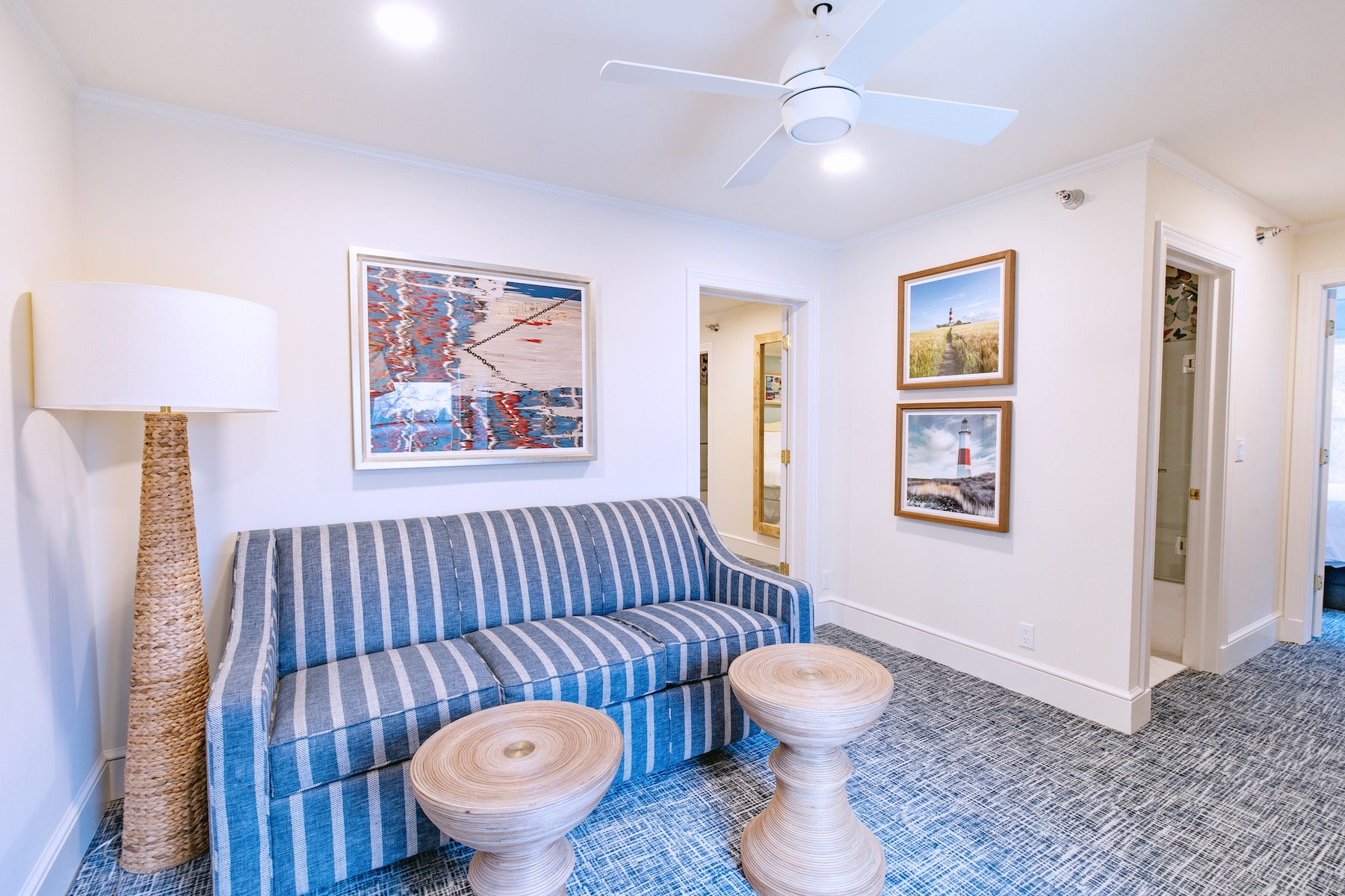 a blue striped couch and two round tables in a room