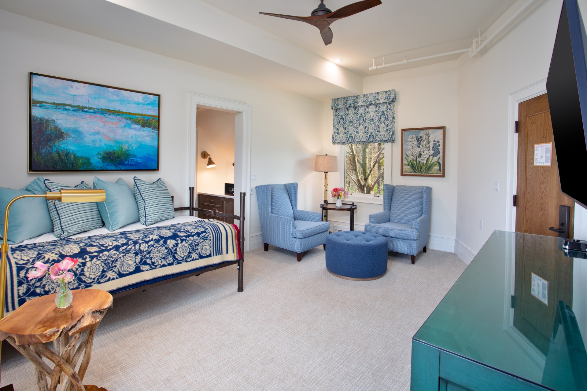 a room with a bed and chairs