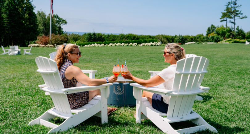 two women sitting in chairs holding drinks