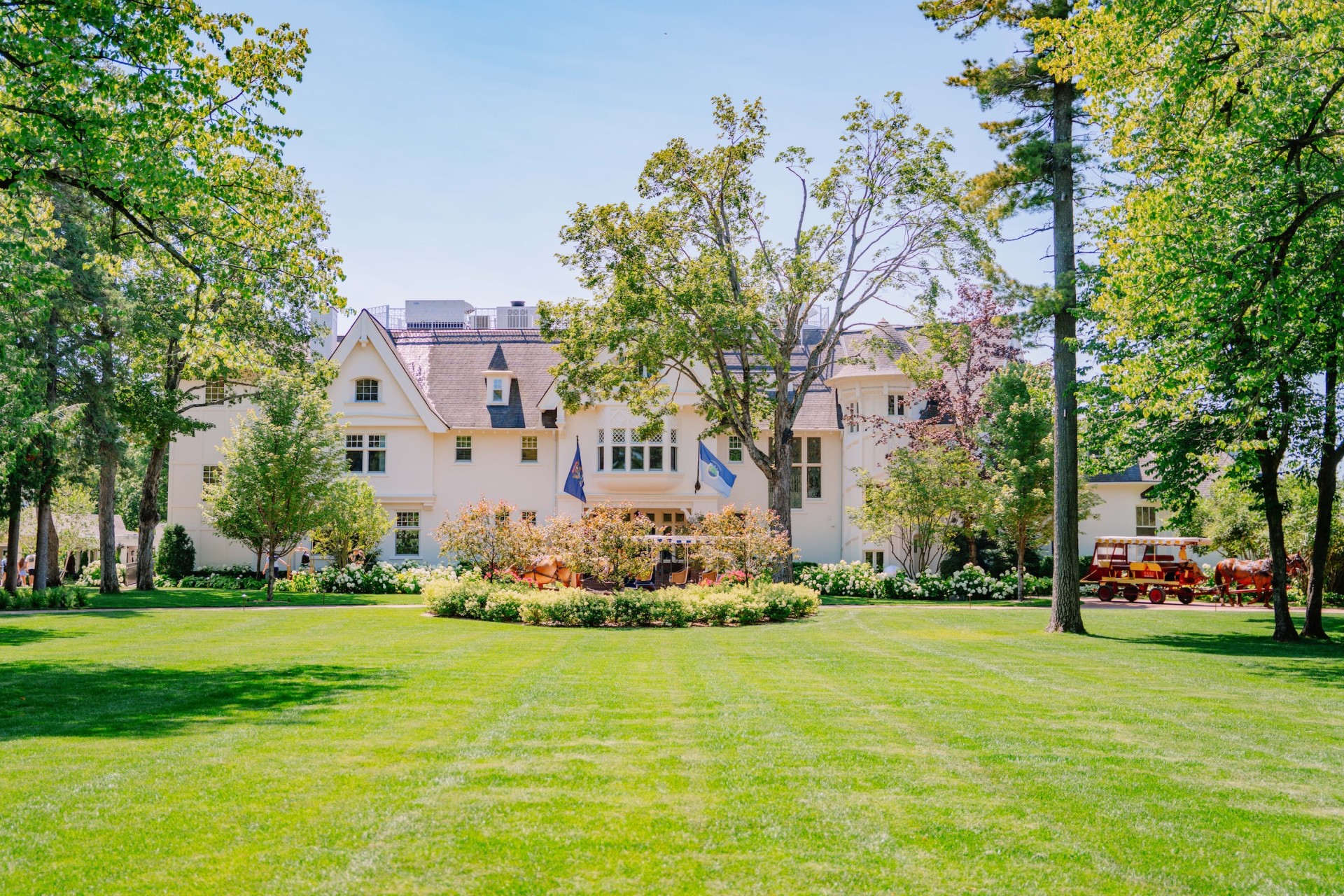 a large white house with a lawn and trees