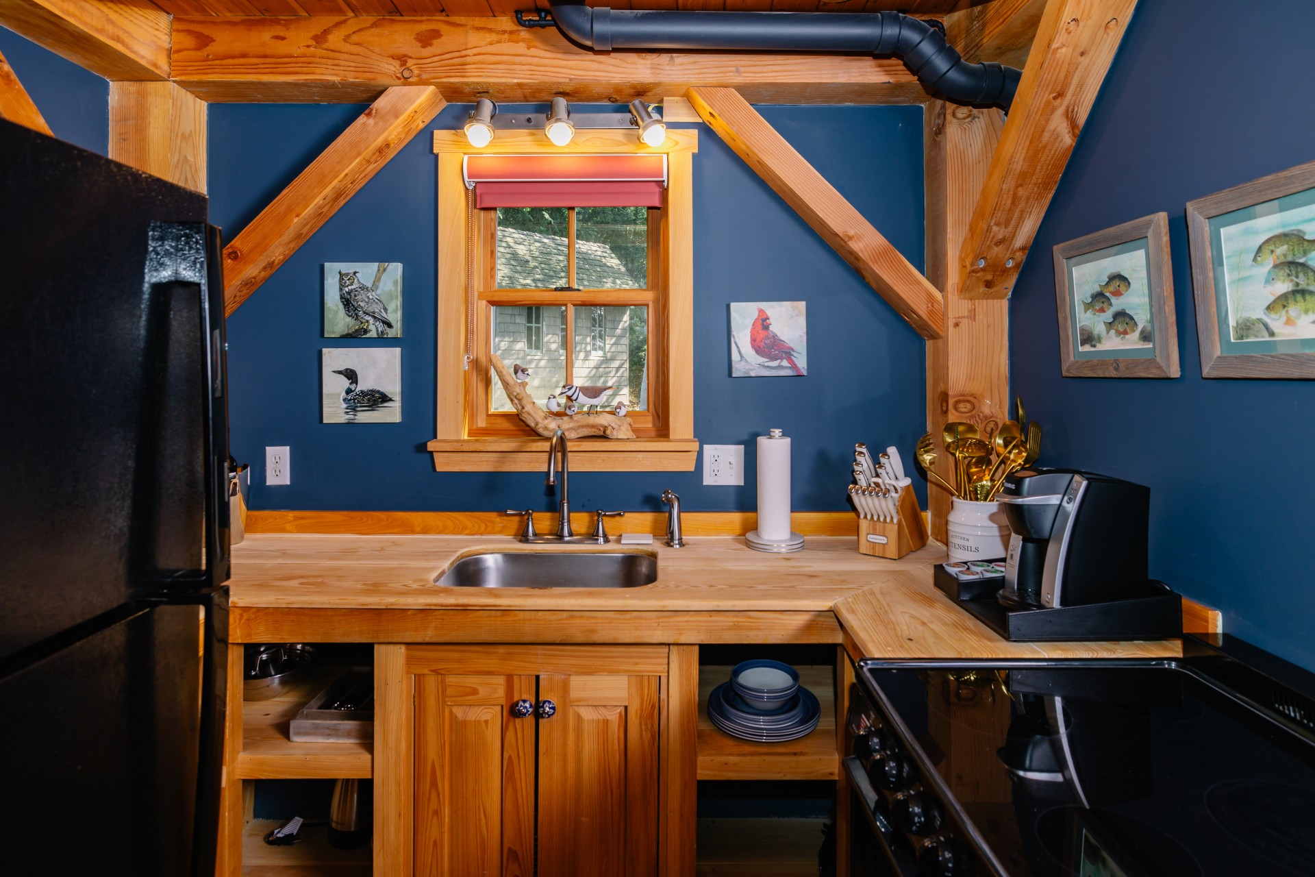 Love Shack Cottage kitchen with wood countertops, exposed beams, and compact full kitchen layout at The Inn at Stonecliffe on Mackinac Island
