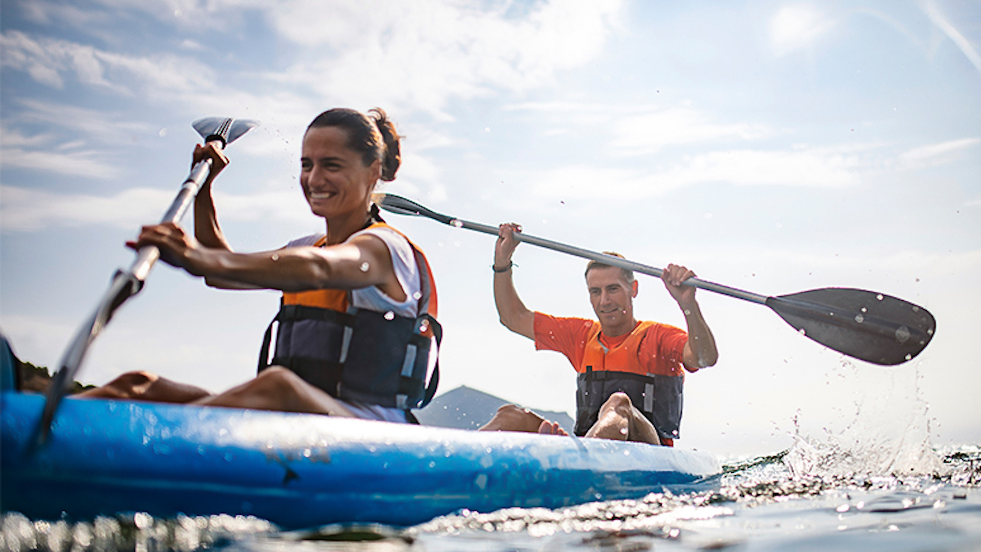 Smiling couple kayaking together on calm waters near Mackinac Island, enjoying outdoor adventure and scenic views during a Stonecliffe getaway