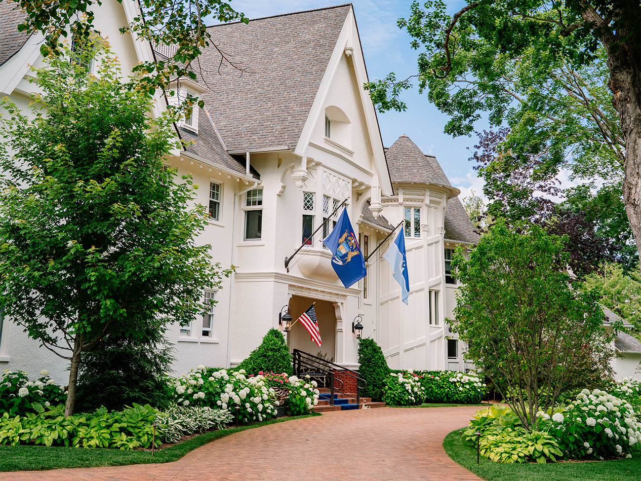 a white house with flags and trees