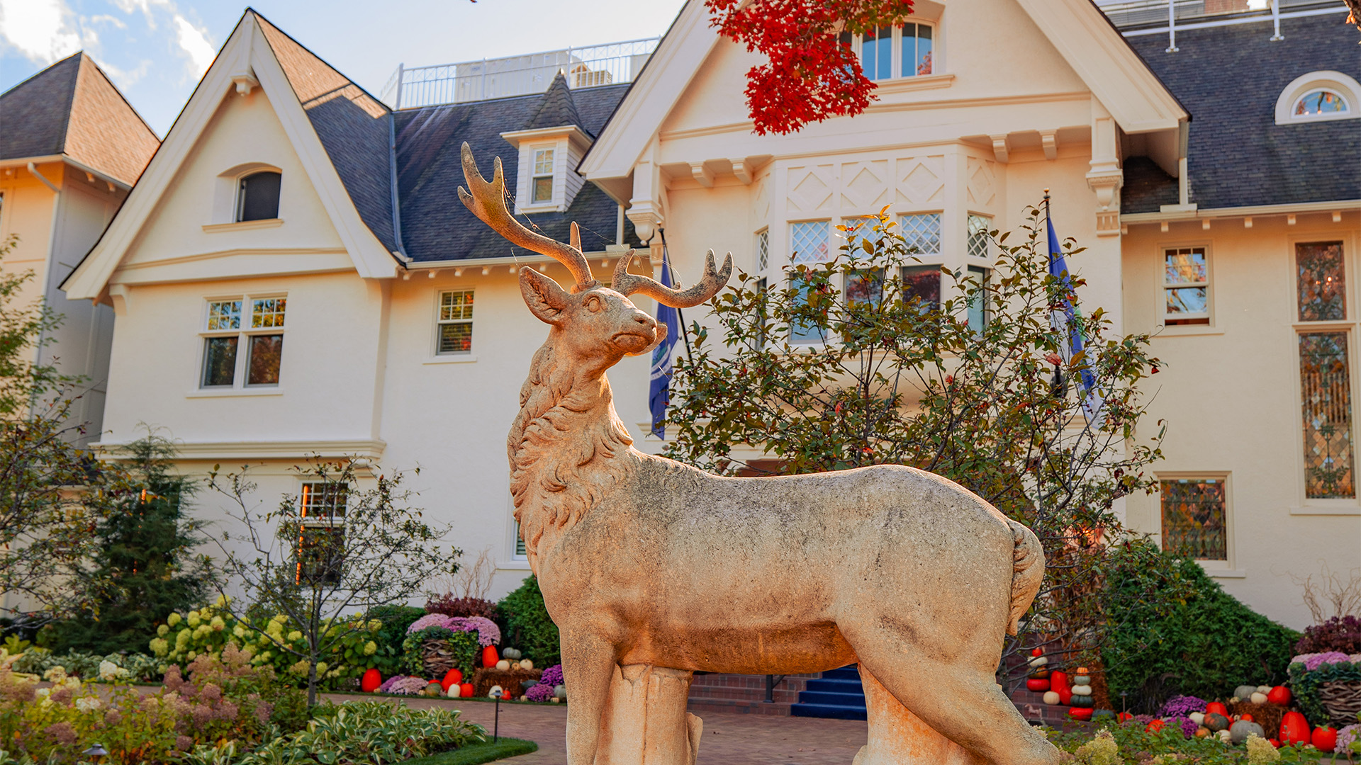 a statue of a deer in front of a house
